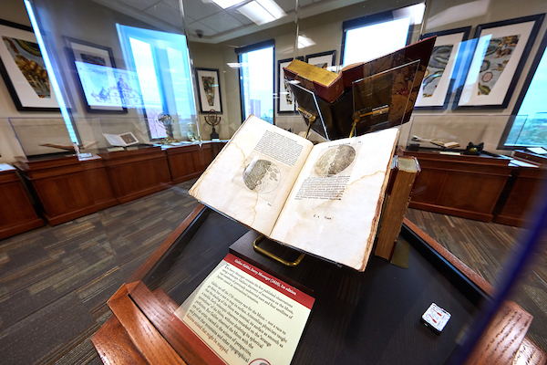 Exhibit room featuring a glass display case with a Galileo book in it